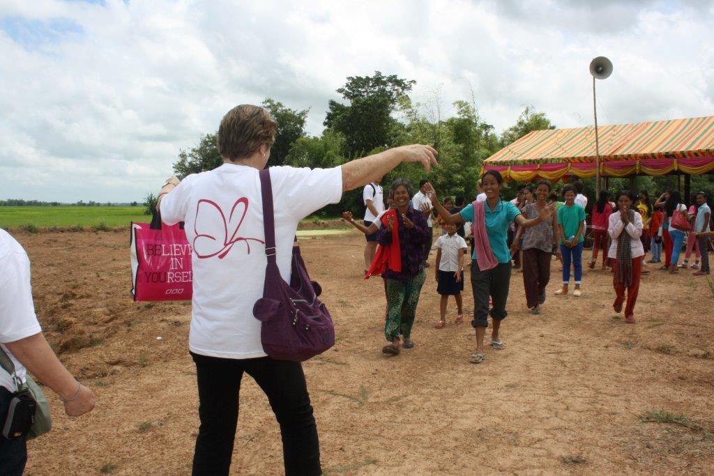 Women in a village left destitute by HIV greet Stitches of Hope staff with wide smiles.