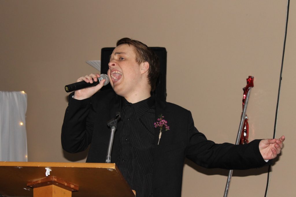 Sam hijacking the microphone to sing at his school ball. 