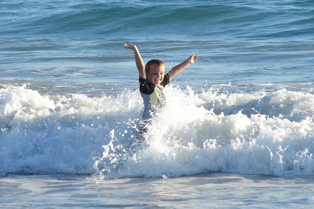 Sam as a child frolicking in the waves at Port Gregory.