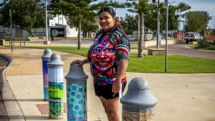 Tahira Kelly standing on the street with one of her Fairy Floss Turtle bollards around Geraldton.